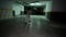 Little boy runing in underground garage, Child around spacious dimly lit parking lot for cars