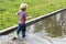 Little boy running into the puddle. Toddler playing in the park
