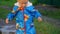 Little boy runs through a puddle in a country