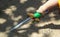 Little boy`s arm with colorful toy wooden sword touching ground with dramatic shadows