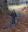 Little boy with a sad face, possibly lost walks a forest path