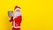 Little boy in Santa Claus clothes and with an artificial beard holding a round gift box in his hands