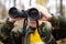 Little boy scout with binoculars during hiking in autumn forest. Child is looking through a binoculars