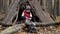 Little boy scout during hiking in autumn forest. Child packs a backpack near a teepee in the woods.