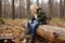 Little boy scout is sharpening a stick with the help knife in the forest