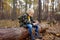 Little boy scout is sharpening a stick with the help knife in the forest