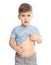 Little boy scratching belly on white background.