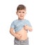 Little boy scratching belly on white background.