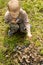 Little boy setting alight to twigs and leaves