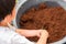 Little boy is shoveling to mixed soil, preparation to plant tree