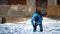 Little boy shovelling snow at winter