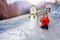 Little boy sit in snow with snowman outside over mountains