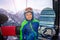 Little boy sit with snowboard in ski lift cabin