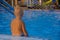 a little boy sits alone near the pool and is sad