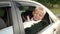 Little boy sits in the backseat of a car in a car seat, he looks out the window