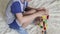 A little boy sits on the floor and collects a plane from a wooden constructor