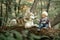 Little boy sits on tree trunk next to lying dog malamute and fee