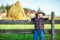 Little boy sits on wooden fence against picturesque haystack
