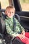 Little boy sitting on a car seat buckled up in the car