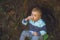 Little boy sitting near a stump