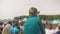 Little boy sitting on parent`s shoulders and looking at car show