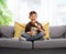 Little boy sitting on a sofa and eating potato chips