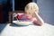 Little boy sitting the table and doesn`t want to eat soup. Healthy food