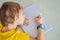 Little boy sitting at the table and looking smart watch. Smart watch for baby safety. The child makes school lessons