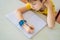 Little boy sitting at the table and looking smart watch. Smart watch for baby safety. The child makes school lessons