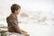 Little Boy Sitting On Wall At Beach