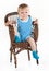 Little boy sitting in wickerwork chair