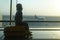 Little boy sitting on a yellow suitcase at the airport and looking at the plane