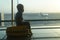 Little boy sitting on a yellow suitcase at the airport and looking at the plane