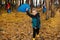 Little boy skip walking with a trash bag in a seasonal forest at autumn