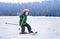 Little boy slides on skis down along the snow slope