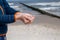 A little boy slowly lets sand flow through his hands scattered by the wind