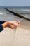 A little boy slowly lets sand flow through his hands scattered by the wind