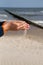 A little boy slowly lets sand flow through his hands scattered by the wind