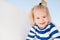 Little boy smile in navy clothes. Happy child enjoy sunny day. Kid smiling with blond hair ponytail. Kids fashion and style. Summe