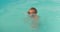 Little boy with snorkel mask plays and learns to dive and swim in the pool