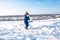 Little boy with a snow shovel in winter in the park. Happy carrying snow on a shovel in casual clothes.