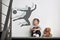 Little boy with soft toy dreaming to be soccer player. Silhouette of man behind kid`s back