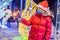 Little boy with sparklers near giant fir tree and Christmas illumination on Christmas market wear medical masks due to