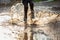 Little boy splashing in a mud puddle,