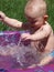 Little boy splashing and Playing on a summer day in a wading pool