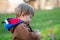 Little boy standing in autumn park whit daisy