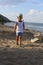 Little boy standing on the sand on the beach near the river