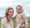 Little boy standing, woman mother, autumn day in nature in field, a warm beige sweater with a hood. Emotions of care