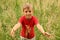 Little boy stands in high green grass