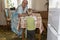 Little boy stands near the kitchen table and begs candy at the grandmother.